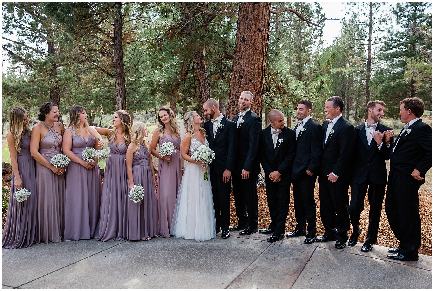 A portrait of the wedding party having conversation while the couple looks at eachother lovingly. 